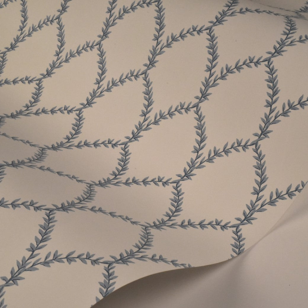 Blue/White Laurel Wallpaper (60 SqFt) by York Wallcoverings features a blue leafy vine pattern on a cream background—ideal for botanical wallpaper enthusiasts or those inspired by Rifle Paper Co.'s Laurel designs.