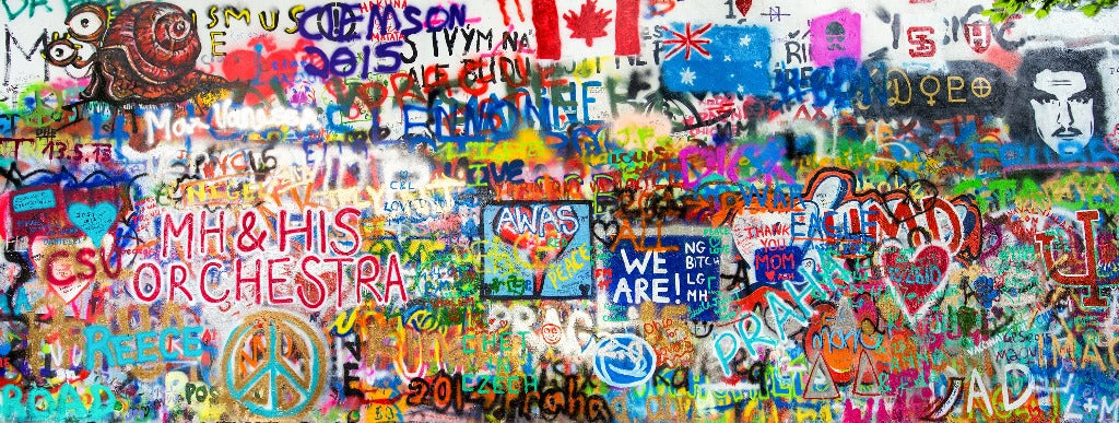 A vibrant and colorful Creative Freedom Wallpaper Mural by Decor2Go featuring a mix of tags, artistic drawings, national flags, and various expressive phrases, showcasing a rich tapestry of street art.