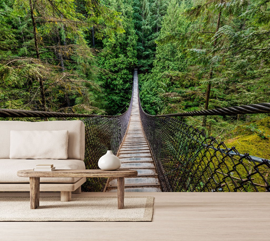 A surreal custom wall mural where a cozy living room setup with a sofa and coffee table seamlessly transitions into the Decor2Go Wallpaper Mural Forest Suspension Bridge Wallpaper Mural.