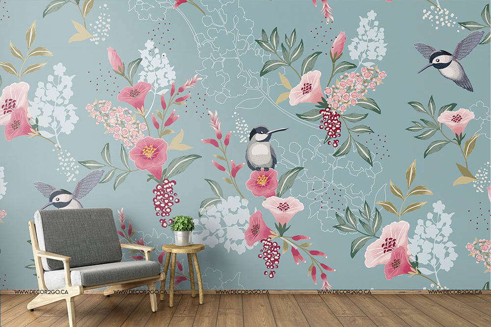 A stylish room featuring an artistic Decor2Go Wallpaper Mural with pink flowers and birds, complemented by a modern gray armchair, and a small wooden side table.