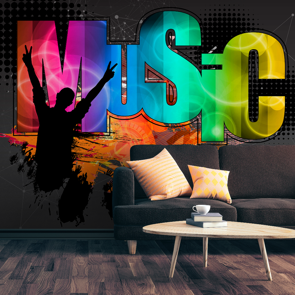 A vibrant Decor2Go Wallpaper Mural featuring the word "music" in colorful, bold letters on a feature wall in a contemporary living room with a dark couch, patterned pillows, a coffee cup on.