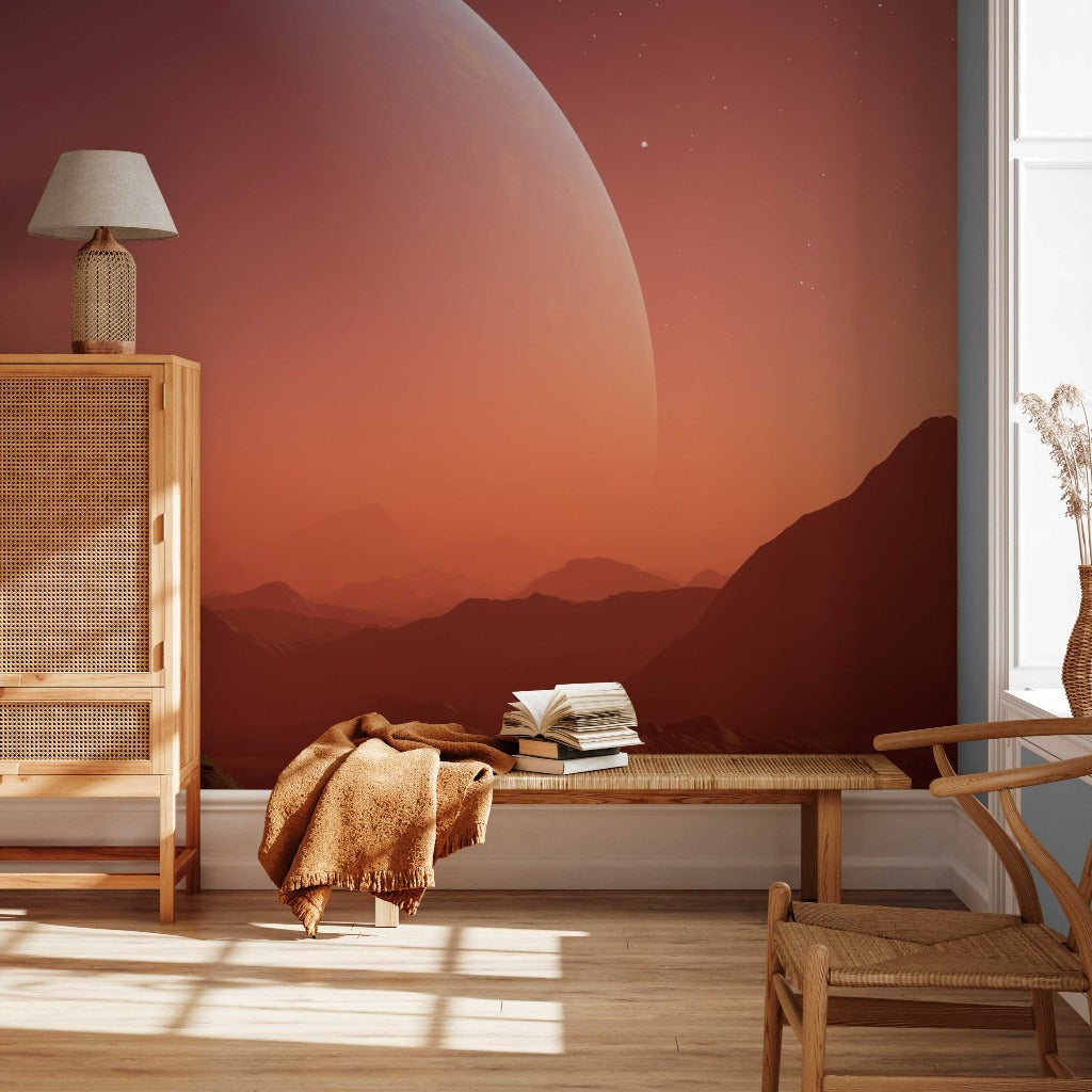A serene room with a large window showcasing a breathtaking view of a vast alien landscape with mountains and a huge planet in the sky, adorned with warm, sunset hues and a feature wall of Decor2Go Wallpaper Mural.