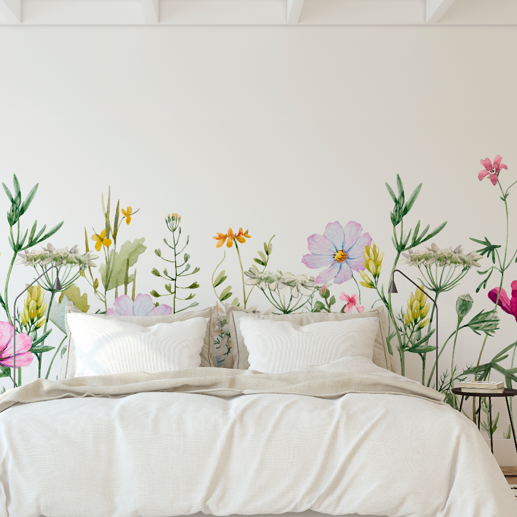 A minimalist bedroom featuring a bed with white linens against a large Decor2Go Wallpaper Mural with vivid, life-sized flowers and greenery on the walls.