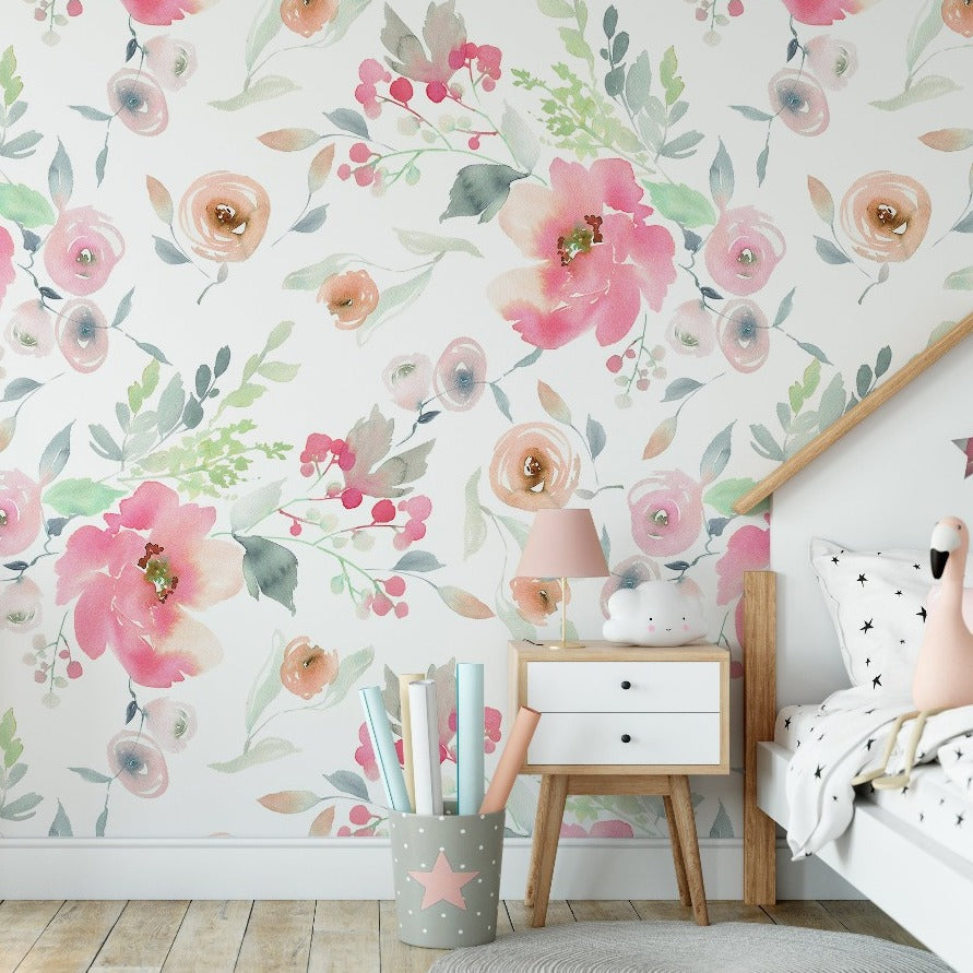 A cozy children's bedroom with a Watercolor Pink Flowers Wallpaper Mural from Decor2Go Wallpaper Mural featuring large pink blossoms, a white bed shaped like a house, and a white nightstand with a pink lamp.