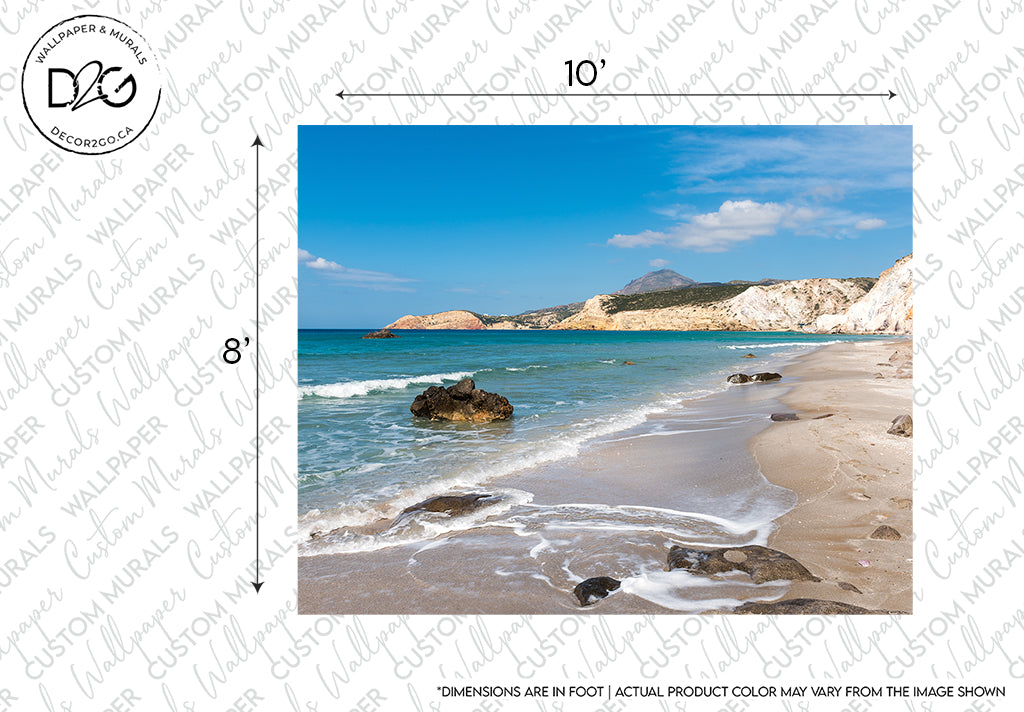A scenic beach landscape with rocky outcrops and gentle surf under a clear blue sky, featuring a backdrop of distant hills and a calming atmosphere, marked by a watermark indicating the image as a sample from Decor2Go Wallpaper Mural's Crystal Coast Wallpaper Mural.