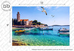 A serene coastal scene features a tranquil blue sea with several boats floating near the shore. An island with historic buildings and a bell tower is in the background, while seagulls soar in the clear blue sky above. This Decor2Go Wallpaper Mural's Riviera Wallpaper Mural showcases a wide-angle perspective, sized at 13' by 9'.