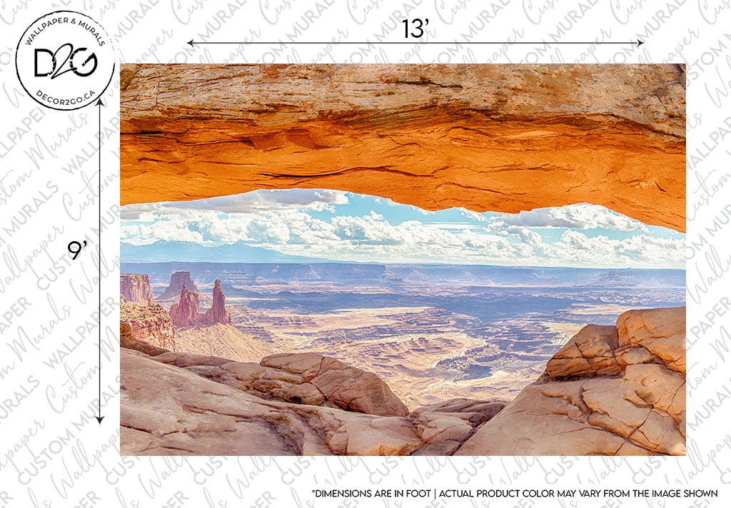 A picturesque view of a desert landscape seen through Arch's Horizon Wallpaper Mural, showcasing expansive sandstone formations under a bright blue sky with fluffy clouds by Decor2Go Wallpaper Mural.