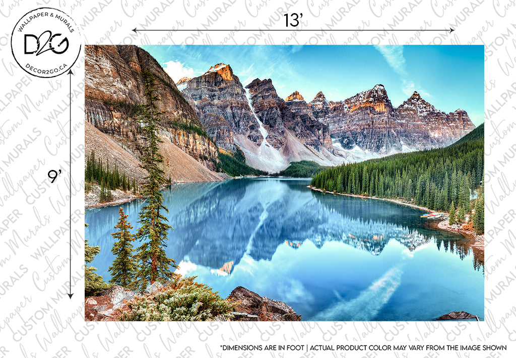 A Banff Panorama Wallpaper Mural from Decor2Go Wallpaper Mural showcasing a panoramic view of Moraine Lake in Banff National Park, Canada, displaying the vibrant blue water and the towering, snow-capped Rocky Mountains reflected in the lake, with lush green trees.