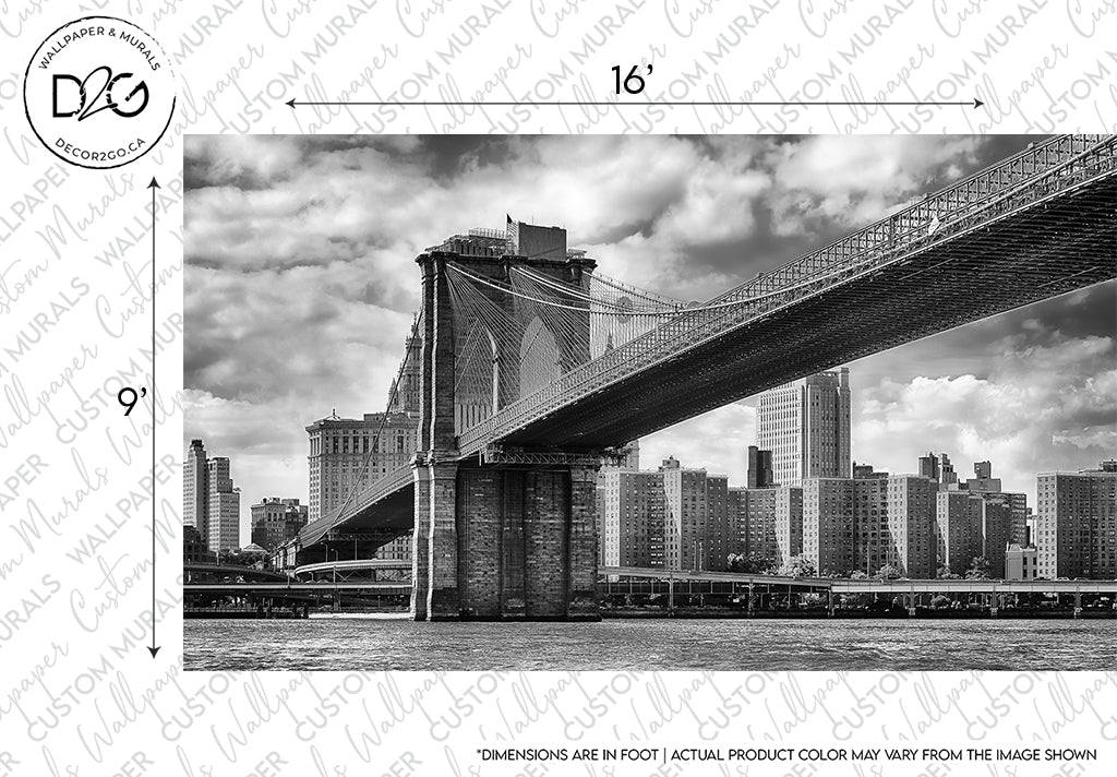 Black and white architectural design photo of the Decor2Go Wallpaper Mural Brooklyn Bridge Wallpaper Mural stretching over the East River, with a view of the New York skyline under a cloudy sky, with labeled dimensions and a watermark.