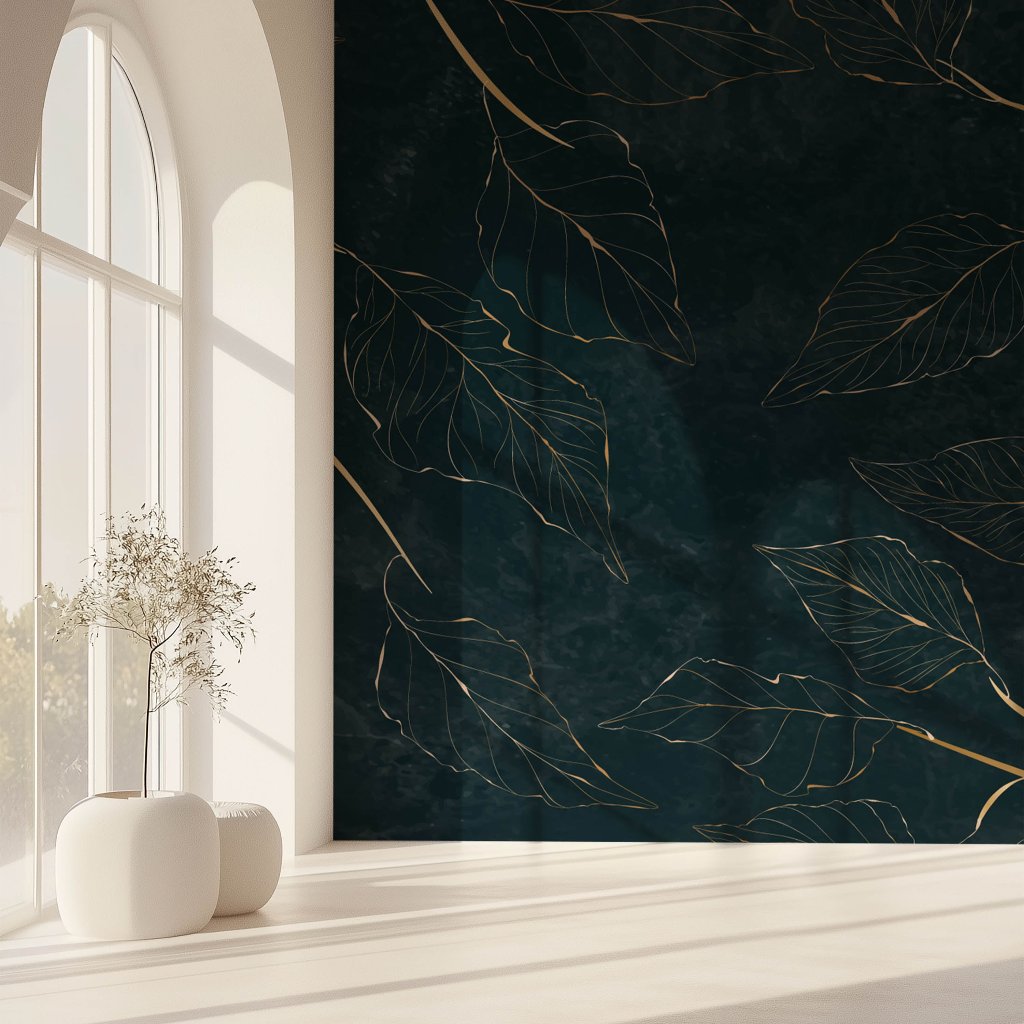 A serene room with a large window casting light on the floor showcases Nature's Elegance. The wall features Decor2Go Wallpaper Mural's Golden Leaves design. Two white cylindrical stools sit near a delicate plant in a transparent vase, exuding premium quality.