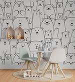 A children's playroom with a wall covered in a Decor2Go Wallpaper Mural Bear Family Black & White Wallpaper Mural. There are two modern chairs, a small table with toys, and a circular rug on a wooden floor.