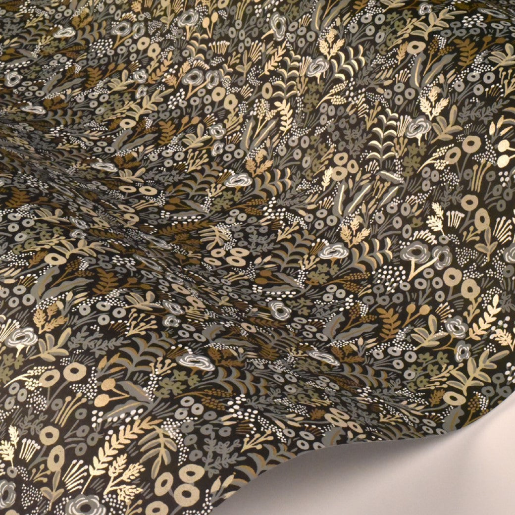 A close-up of York Wallcoverings' Black/Beige Tapestry Wallpaper (60 SqFt) shows textured, dark tones with intricate gold, beige, and white floral patterns overlapping in dense arrangements for a botanical-inspired look.