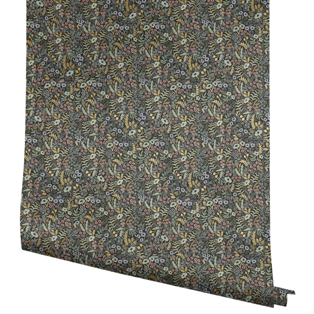 A roll of York Wallcoverings Black Tapestry Wallpaper (60 SqFt) featuring a dense, intricate floral pattern with small flowers and leaves in muted greens, yellows, pinks, and blues against a dark background.
