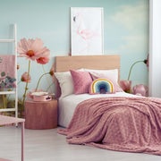 Bedroom - A cozy bedroom with a soft pink and beige color scheme, featuring a bed with a pink quilt, a rainbow-shaped pillow, and vibrant blooms framed as the Decor2Go Wallpaper Mural on the wall.