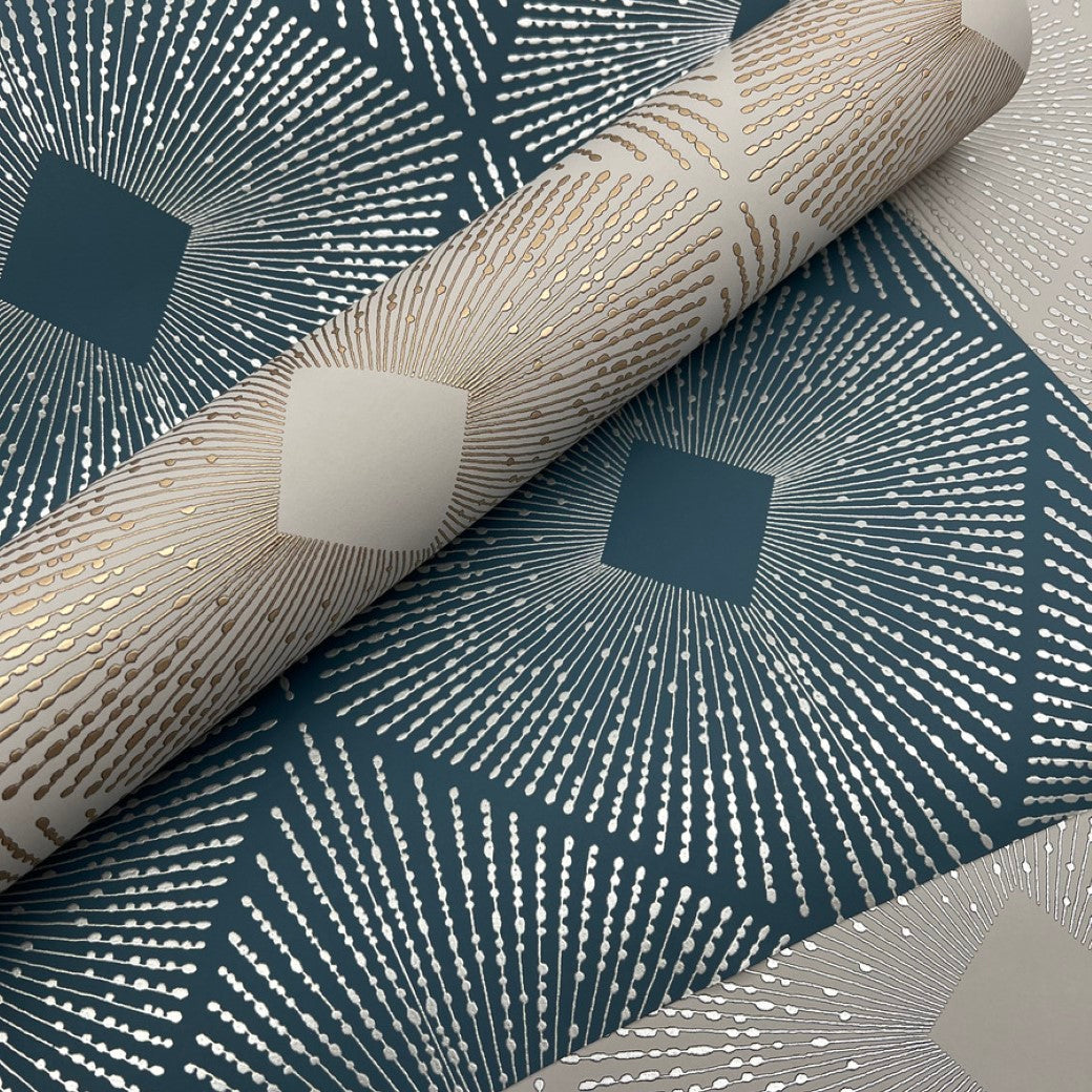 The Blue & Silver Harlowe Wallpaper from York Wallcoverings features a geometric design with silver metallic lines and diamond shapes on a teal background, creating an elegant, light-reflecting effect with its repeating pattern.