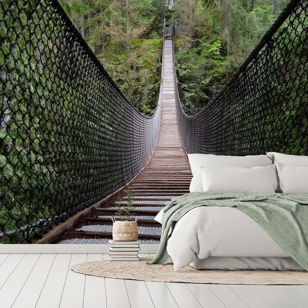 A digitally created bedroom with a serene forest view features a unique wall mural of the Bridge Amid the Forest Wallpaper Mural from Decor2Go Wallpaper Mural, depicting a suspension bridge leading deep into lush greenery, perfectly framed behind a cozy bed with soft bedding.