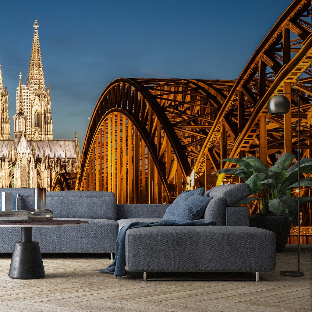 A modern living room with a gray sectional sofa and a minimalistic coffee table set against a surreal backdrop of European architecture, including Decor2Go Wallpaper Mural's Bridge and Cathedral View Wallpaper Mural.