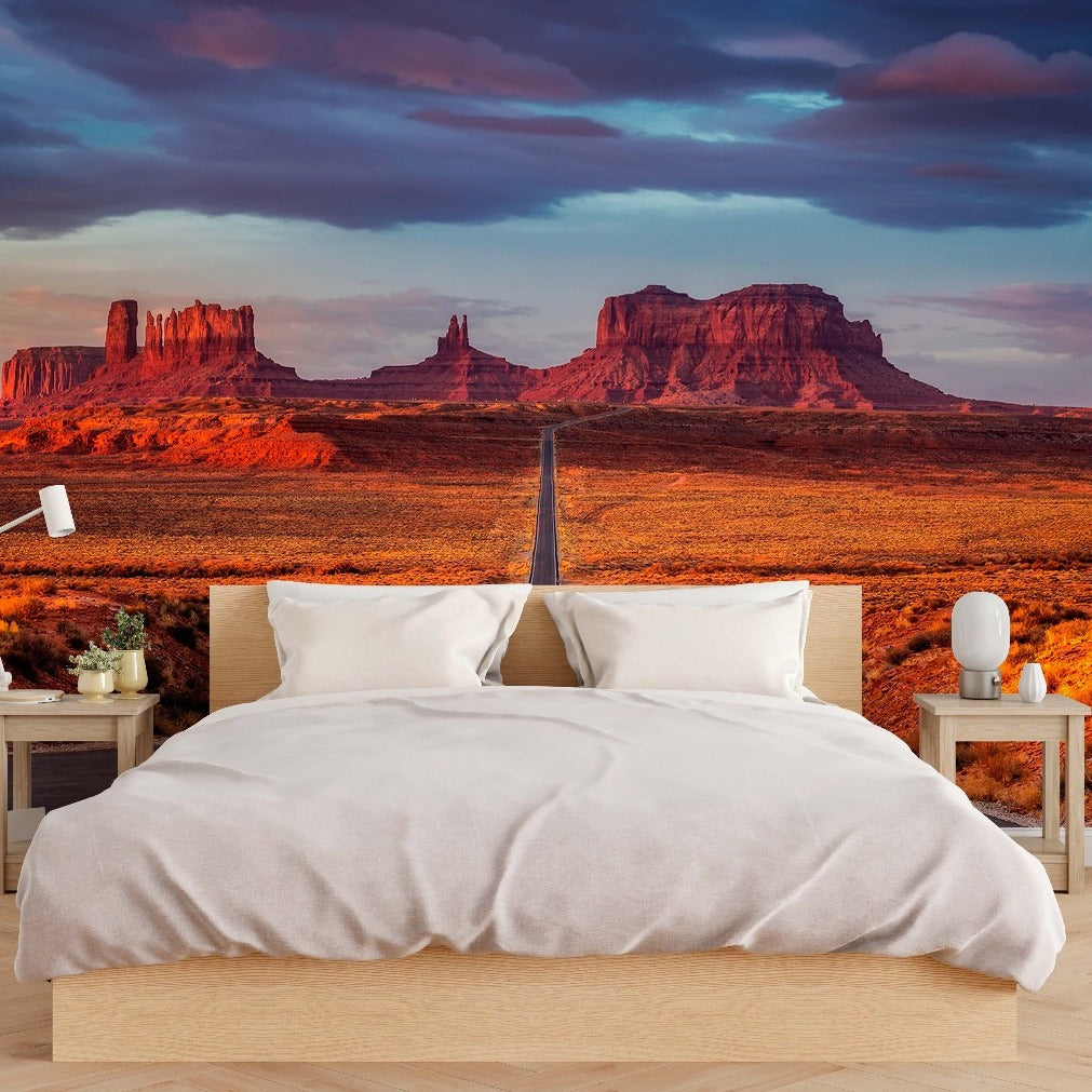 Bedroom - A modern bedroom with a large bed, nightstands, and lamps, with a wall-sized Decor2Go Wallpaper Mural displaying a vivid desert landscape featuring monumental red rock formations under a dramatic sky.