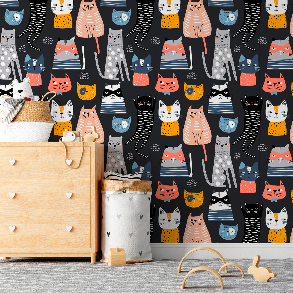 Nursery - A nursery room featuring a wall covered in Decor2Go Wallpaper Mural's Cartoon Cats Wallpaper Mural with colorful cat illustrations, a wooden crib, a storage basket, and a toy on the floor.
