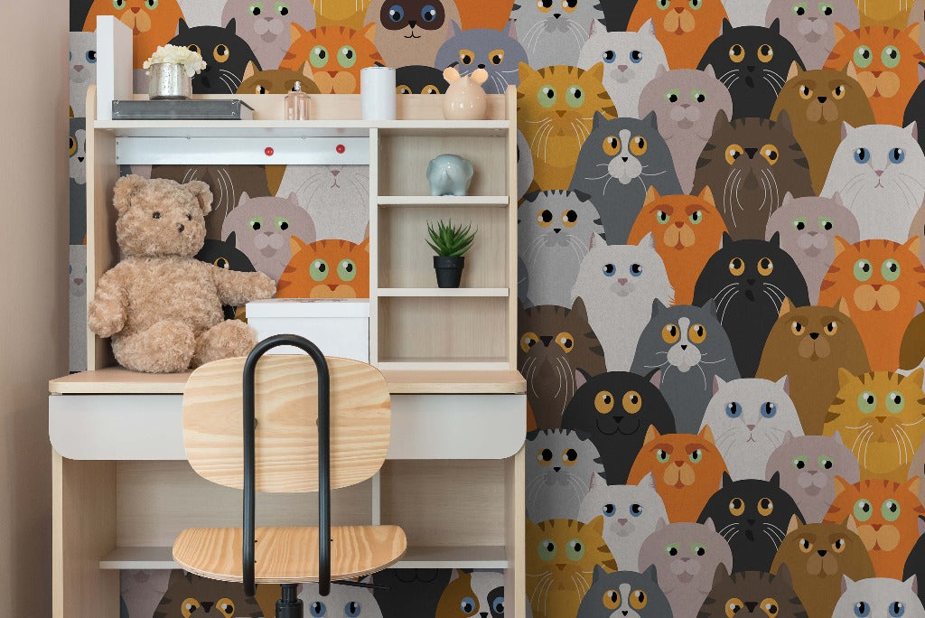 A cozy children's room corner with a white shelf containing a teddy bear, books, a plant, and figurines, against a vivid Decor2Go Wallpaper Mural featuring patterns of furry felines