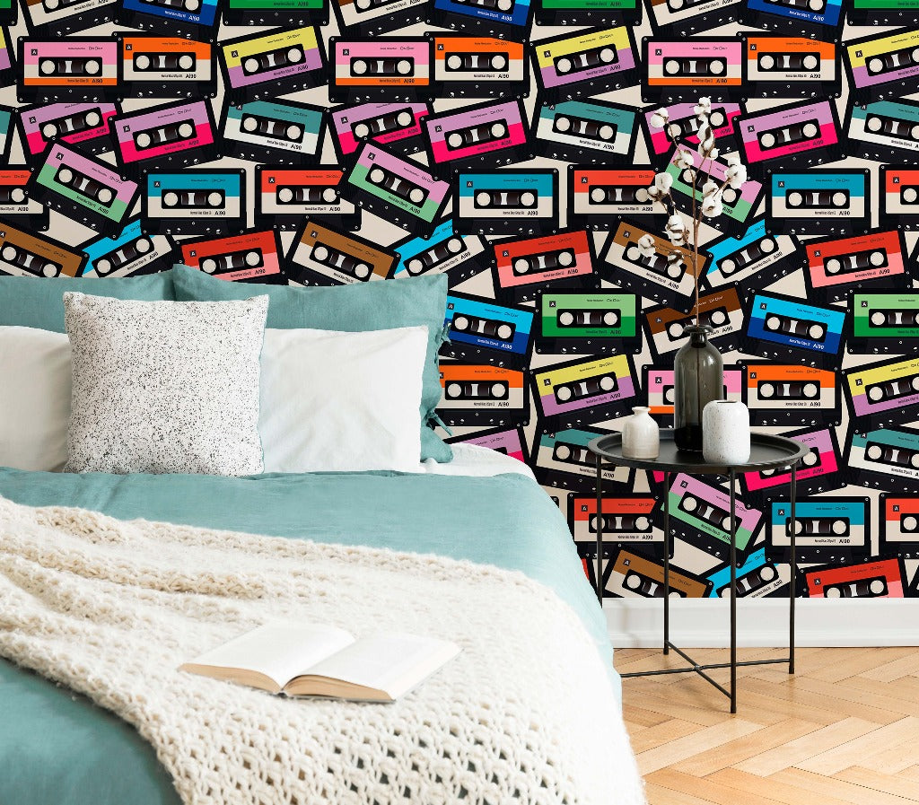 Bedroom - A cozy bedroom corner with a bed covered in a teal blanket and white knit throw, situated against a vibrant wall adorned with a custom-sized mural of Decor2Go Wallpaper Mural Coloured Cassette Wallpaper Mural.