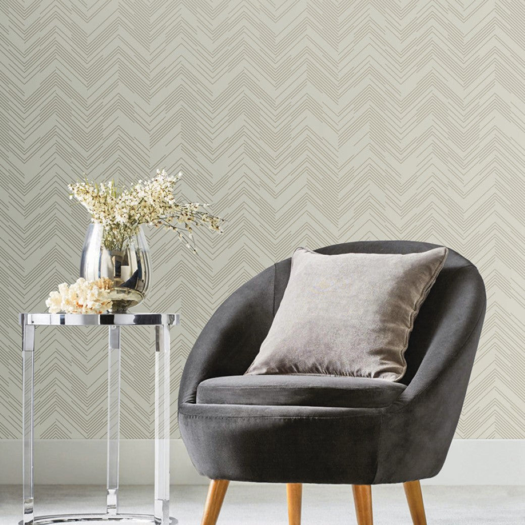 Living Room - modern , a gray round armchair with a matching cushion rests on a light carpet. A sleek glass table with a silver vase of white flowers sits beside it. The chic look is completed by York Wallcoverings' Cream & Gold Polished Chevron Wallpaper (60 SqFt)