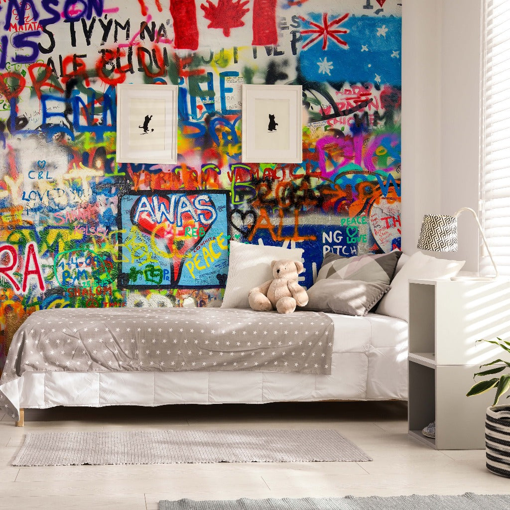 Bedroom - A modern bedroom featuring a single bed with a polka dot cover and a teddy bear, beside a white shelving unit. The room has vibrant, artistic colors with Decor2Go Wallpaper Mural filled with colorful graffiti design.