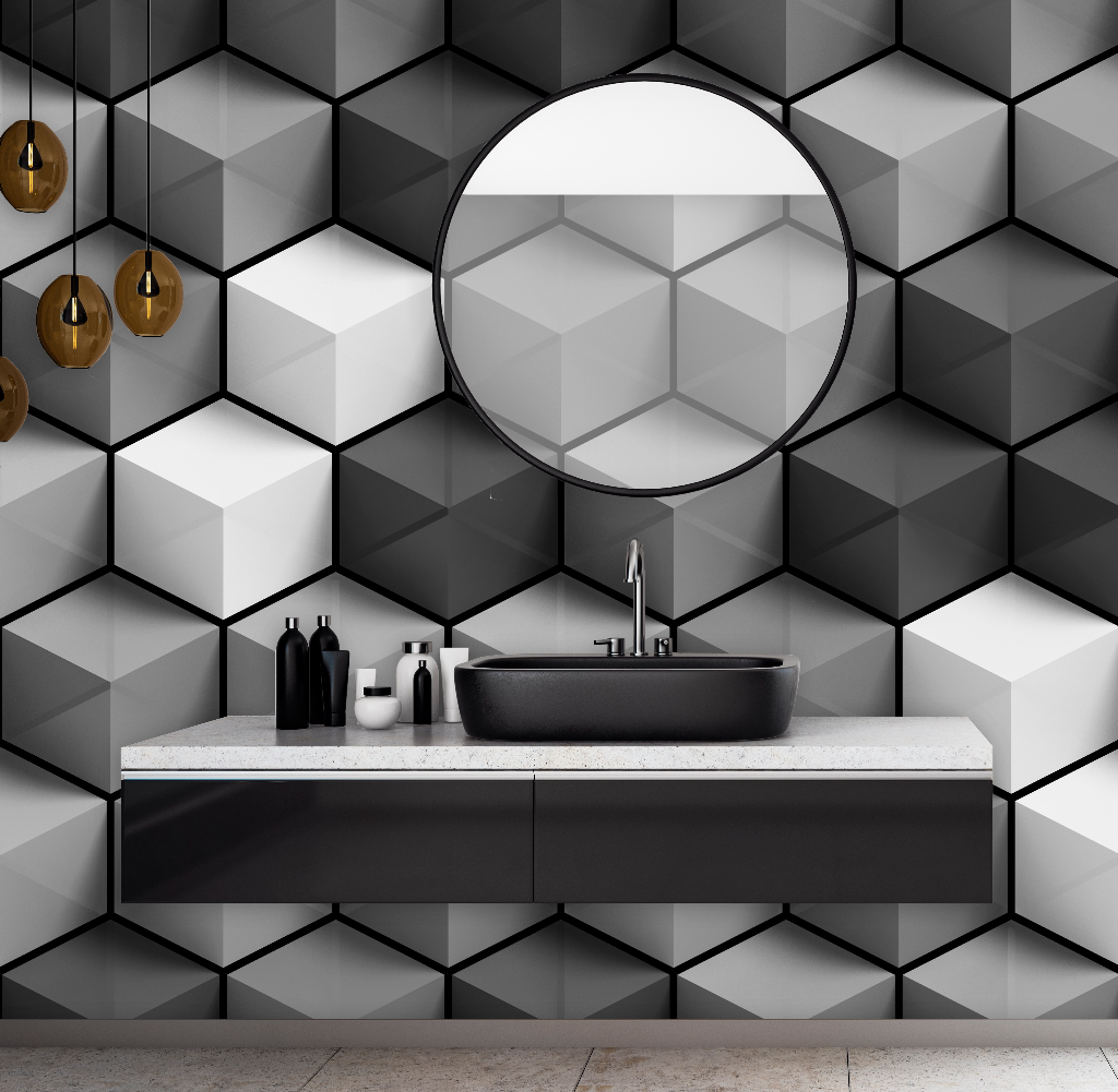 A modern bathroom featuring a black basin on a white countertop, a large round mirror, and Decor2Go Wallpaper Mural's Cubic Grays wallpaper on the walls. Hanging pendant lights add a warm glow.