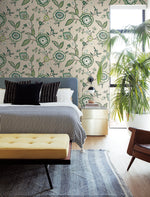 A stylish bedroom with York Wallcoverings Dahlia Blooms Dove/Cornflower Wallpaper Blue, White/Off White (60 Sq.Ft.), a bed with black and white striped bedding, a black and white accent pillow, and a yellow tufted bench at the foot. A potted plant near the window adds botanical elegance, while a rug adorns the wooden floor. A chair is in the corner for easy relaxation.