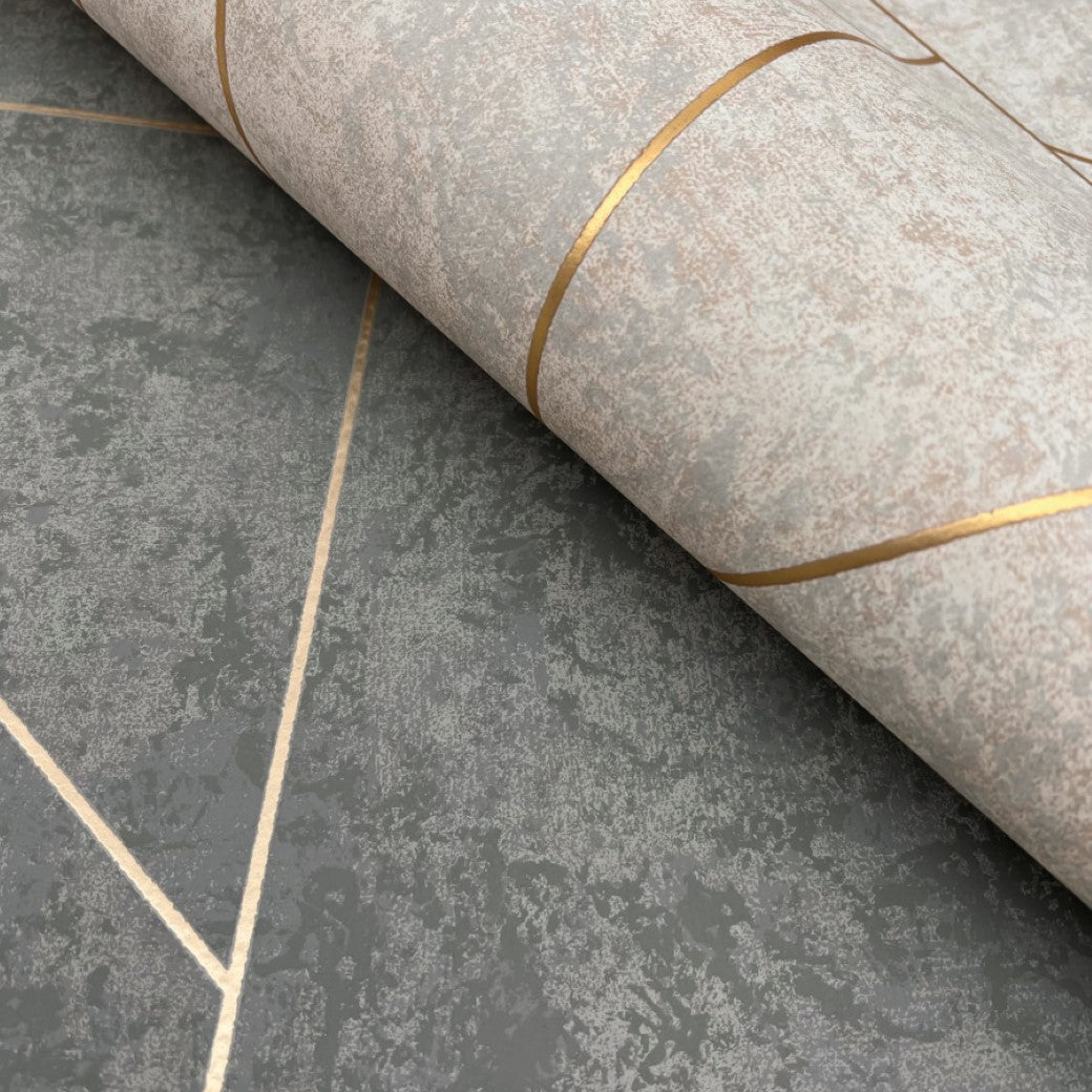 A close-up of York Wallcoverings' Dark Grey & Gold Nazca Wallpaper (57 SqFt) features a metallic geometric design. The wallpaper blends gray and green tones with gold lines forming intersecting shapes, delivering a modern and sophisticated look.