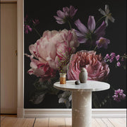 Entry Way - A round stone table with a small vase and an abstract ceramic decoration is set against the Decor2Go Wallpaper Mural's Midnight Peony Floral Wallpaper Mural, which showcases large pink and purple flowers. This scene beautifully illustrates a modern and elegant interior design, with dark floral patterns adding depth seamlessly.
