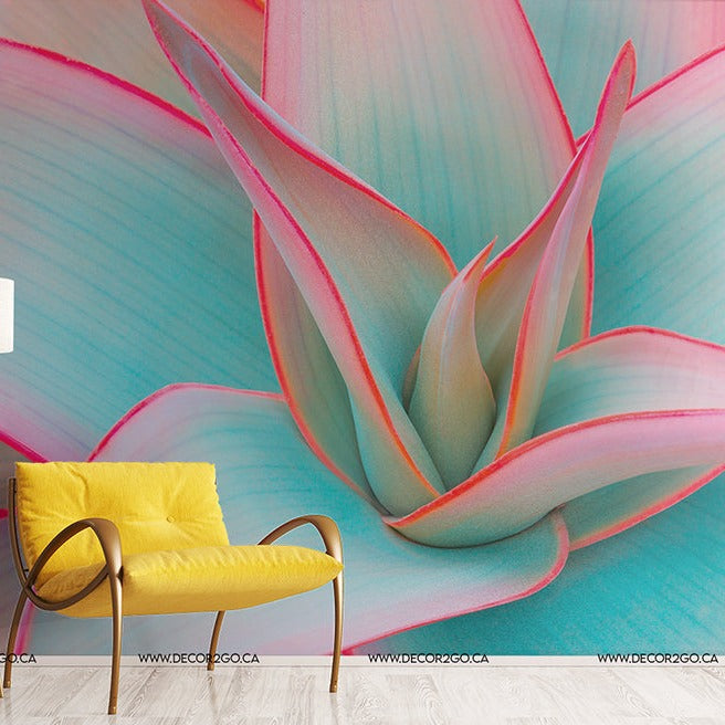 A vibrant room featuring a large Decor2Go Wallpaper Mural Desert Oasis in shades of pink and blue as a backdrop. A stylish yellow chair and a white standing lamp are positioned in front of the wall.