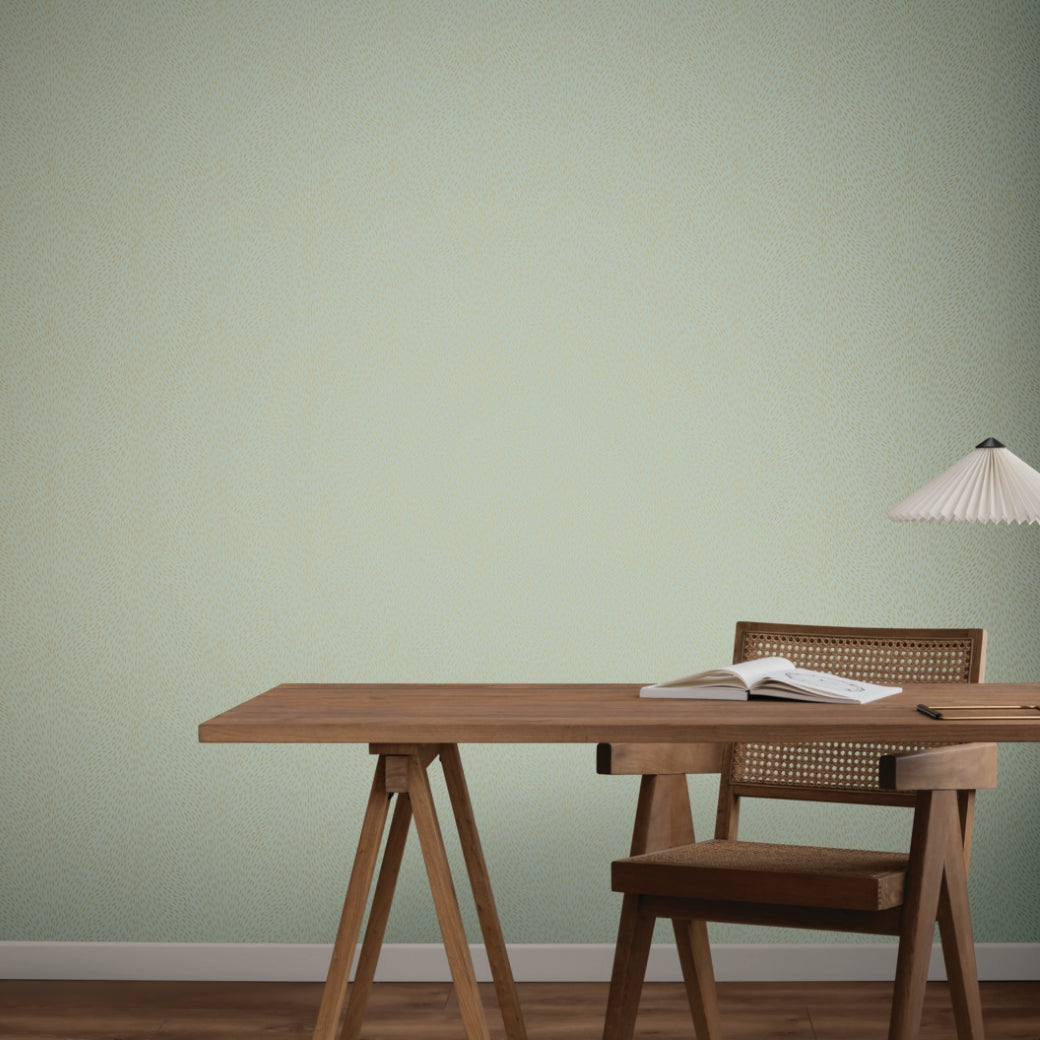 Home Office - A minimalist features a wooden desk and chair, an open book, and a hanging lamp set against York Wallcoverings’ Dew Drop Sea Mist Wallpaper (60 SqFt), creating a serene scene with natural tones and clean lines