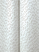 A close-up of York Wallcoverings' Dew Drop White Wallpaper (60 SqFt) shows metallic silver fabric with small, evenly spaced textured dashes in a subtle, repeating pattern and a vertical central seam—evoking the look of glitter wallpaper.