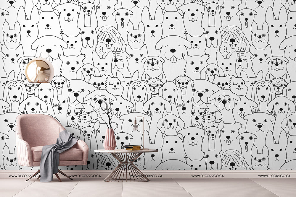 A cozy corner with a pink armchair and a gray blanket beside a small table, against a wall covered in Decor2Go Wallpaper Mural featuring various dog illustrations.