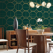 Dining Room - Elegant with wooden furniture and a round table, highlighted by York Wallcoverings' Emerald & Gold Sun Circles Wallpaper. A modern chandelier with metallic finishes hangs above, and the sideboard showcases decorative vases along with an orchid plant