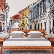 Bedroom - A modern bedroom with a large bed featuring crisp white linens and wooden frame, flanked by matching nightstands with lamps, set against a vibrant Decor2Go Wallpaper Mural of a charming city European Alley Watercolor Wallpaper Mural.