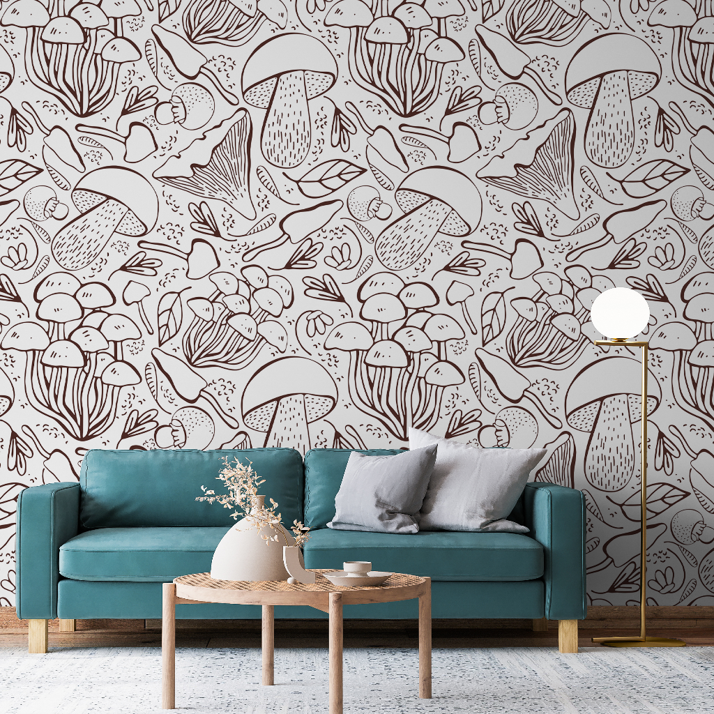 A cozy living room featuring a teal sofa with gray pillows, a small wooden coffee table crafted with local craftsmanship, and a floor lamp. The walls are adorned with Decor2Go Wallpaper Mural featuring whimsical mushroom and Exotic Plants Sketch.