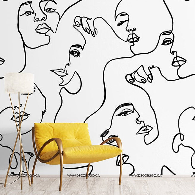 A modern room with a white wall featuring a Decor2Go Wallpaper Mural of Familiar Faces. A bright yellow chair and a minimalist lamp stand beside it.