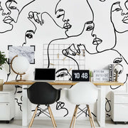 Home Office - A modern home office with a desk featuring a laptop, a globe, and decorative items. The wall behind is adorned with a unique Familiar Faces Wallpaper Mural from Decor2Go Wallpaper Mural depicting abstract faces. Two chairs are in front.