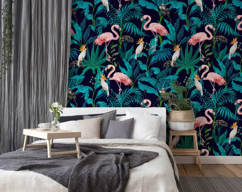 A stylish bedroom with a dark tropical Decor2Go Flamingo Fever Wallpaper Mural, modern white bed with grey bedding, wooden coffee table, plant in a corner, and sheer gray curtains.