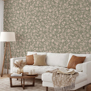 Living Room - A cozy living room featuring a white sofa with brown and beige cushions, a wooden coffee table with books and decor, a floor lamp, and a wall with Floral Bliss Wallpaper Mural by Decor2Go Wallpaper Mural on a green background.