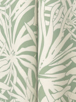 Close-up of York Wallcoverings' Floral Canopy Olive Wallpaper (60 SqFt), showcasing a botanical pattern of large abstract white leaves and flowers on a muted green background with a visible vertical seam.