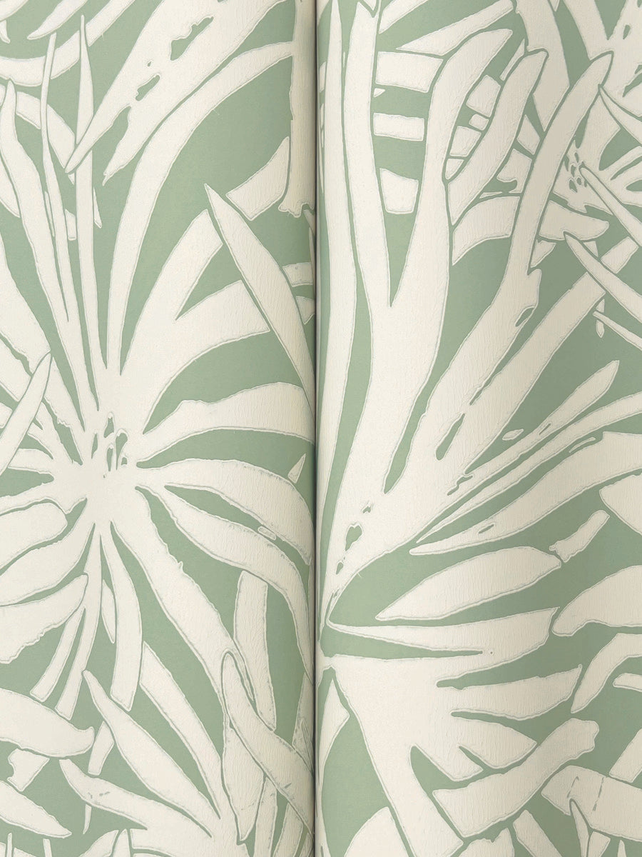 Close-up of York Wallcoverings' Floral Canopy Olive Wallpaper (60 SqFt), showcasing a botanical pattern of large abstract white leaves and flowers on a muted green background with a visible vertical seam.