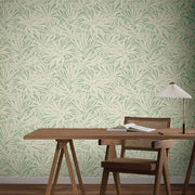 Home Office - A minimalist features a wooden desk, chair, lamp, open notebook, and York Wallcoverings' Floral Canopy Olive Wallpaper (60 SqFt), adding calming green and cream botanical patterns to the background
