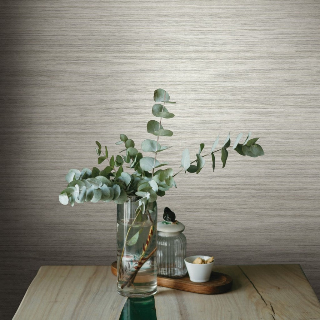 Beige grass sand wallpaper on the wall, table in the front with green leaves in a pot