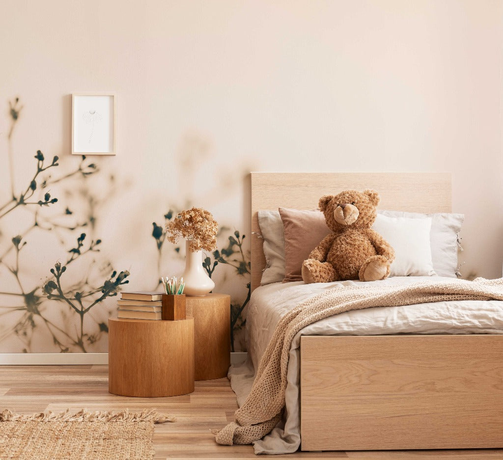 Bedroom - Cozy bedroom featuring a large bed with beige linens and a plush teddy bear sitting on it. Next to the bed is a wooden nightstand with books and a vase of dried flowers, under Decor2Go Wallpaper Mural's Fragile Flowers Wallpaper Mural.
