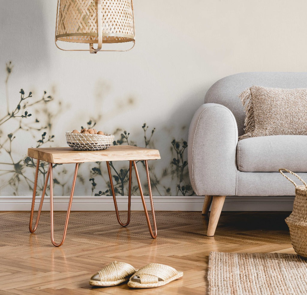 Bedroom - A cozy teen's bedroom corner with a gray sofa, wooden coffee table on copper legs, wicker baskets, slippers on a rug, and a hanging rattan lamp. Light walls adorned with a Decor2Go Wallpaper Mural.