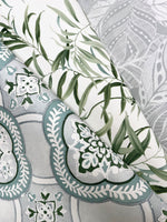 Three sheets of decorative paper are layered in the image. The top sheet, exuding *Garden Trellis Ochre Wallpaper Yellow (60 Sq.Ft.)* by *York Wallcoverings*, features green leaf patterns, the middle sheet has intricate gray and white floral motifs, and the bottom sheet displays ornate teal and white lace-like designs on a gray background.