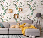 A golden retriever lounges on a gray sofa in a living room with a Decor2Go Wallpaper Mural background. A knitted yellow throw is draped across the sofa, beside a floor lamp.